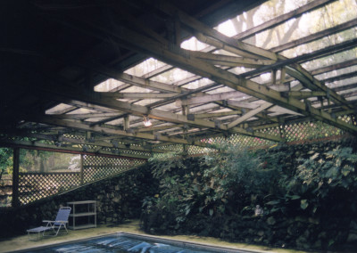 Inside the dark pool enclosure with sagging wood rafters